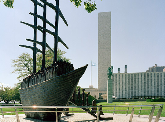 The sculpture (measuring 26 x 24 ft) is made in bronze, entitled “Arrival”  and is by Dublin-born sculptor John Behan.  It weights more than 11 tons, and depicts emigrants disembarking from the ship along two gangplanks towards New York’s East River. It was presented by the Irish Government to the UN in 2000.